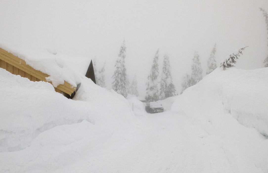 HELT NEDSNØDD VÆR: Nedsnødde og innesnødde hytter i tåke på Sjusjøen, der det har lagt seg store mengder snø og brøytekantene er historisk høye. Foto: Berit Roald / NTB scanpix