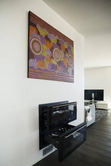 FRA AUSTRALIA: Familien har vært på ferie i Australia og bildet er tradisjonell aboriginer-kunst. Det symboliserer vannkilder og energi. Under er et integrert vinskap i to etasjer. FOTO: Elias Dahlen