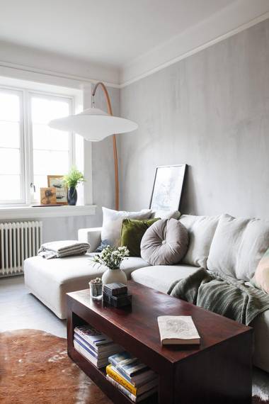 SOFAKROK: Den lille stuen rommer en romslig sofa. I stedet for at bilder henges på veggen, er de i stadig forflytning fra rom til rom, enten stående opp mot veggen eller oppå møbler. FOTO: FILIPPA TREDAL