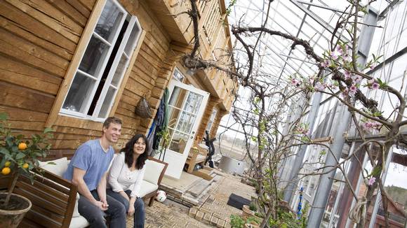 FRUKTBLOMST: Ekteparet Solvarm betrakter humla som har våknet fra vinterdvalen og er i full gang med pollinering av fruktblomstene. I løpet av kort tid vil det være tett av grønne vekster rundt tømmerhuset. FOTO: Karen Gjermundrød
