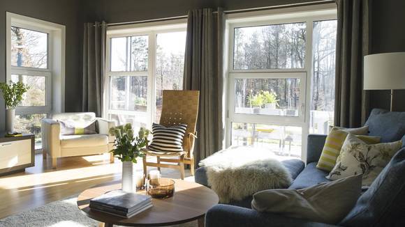 LYST. De store vinduene slipper inn mye lys, og gjør at leiligheten oppleves luftig selv om den er malt mørk. Den klassiske stolen, designet av Bruno Mathsson, har hun overtatt av sin far. FOTO: BØRRE ESKEDAHL