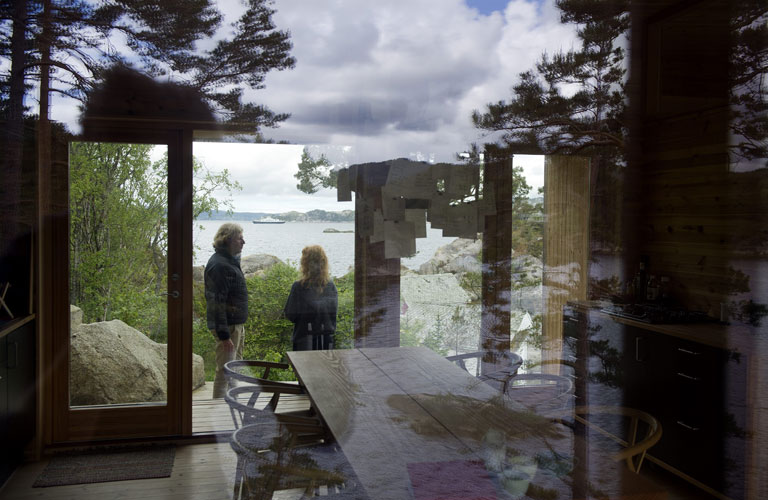 BINDER SAMMEN: Vinduer fra gulv til tak på begge sider av hytten slipper naturen inn. Både inne på kjøkkenet og ute er det god plass, og passer både til to og tjue gjester. FOTO: Helge Skodvin