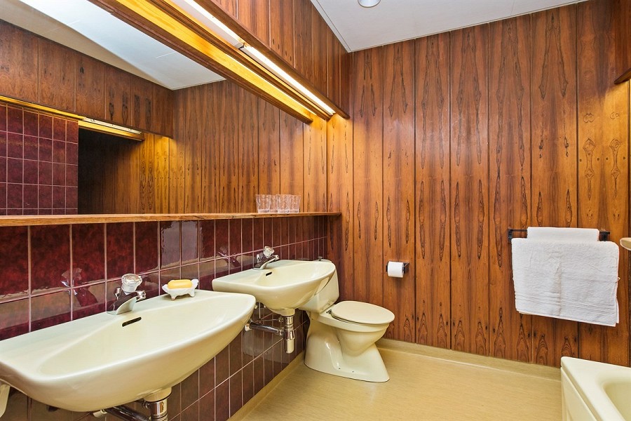 TEAK OG MAHOGNY: Til og med på badet holder man seg i det rundt 40 år gamle tiåret. FOTO: Privatmegleren